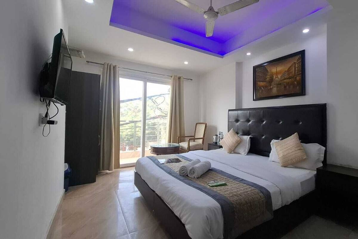 Un dormitorio moderno con una cama grande, un ventilador de techo y un cuadro en la pared.