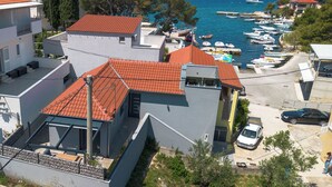 A coastal residential area with modern buildings, a marina with boats, and a clear view of the sea. - House Luxury Konforta (Sibenik)