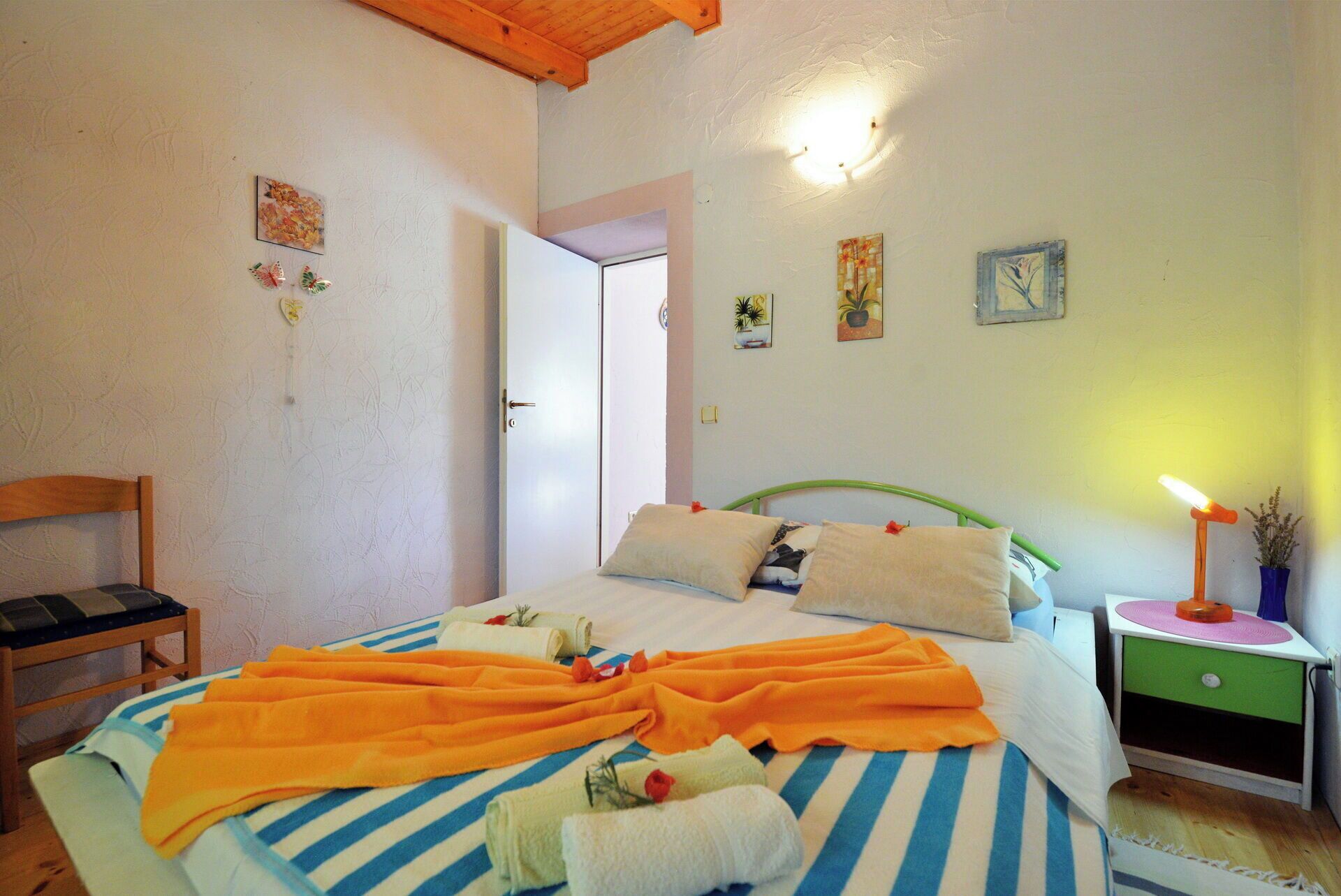 Une chambre à coucher comprenant un lit, une chaise, une table de chevet et une commode.