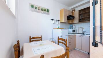 A compact kitchen with wooden cabinets, a microwave, and a coffee maker.