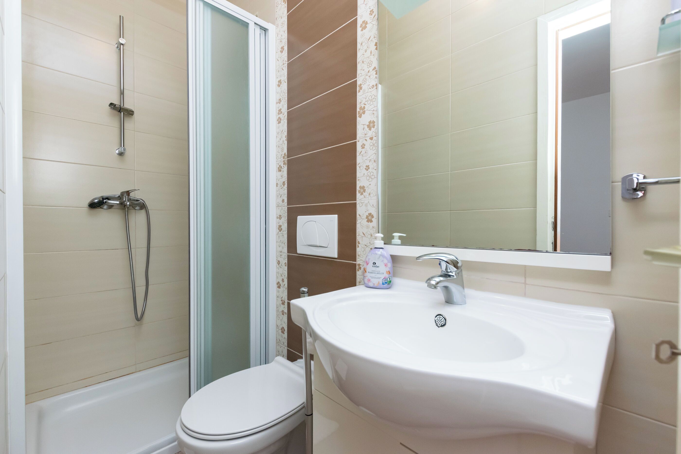 Un baño con inodoro, lavamanos y ducha.