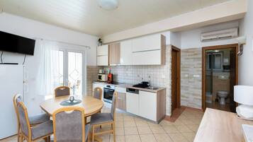A compact kitchen with a dining area, a built-in oven, and a microwave.