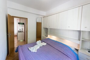 A bedroom with a bed, a wardrobe, a bedside table, and a mirror. - House Cvijeta (Lumbarda)