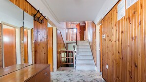 A hallway with wooden paneling, a staircase, and a mirrored wardrobe. - Apartments Milena (Lopar)