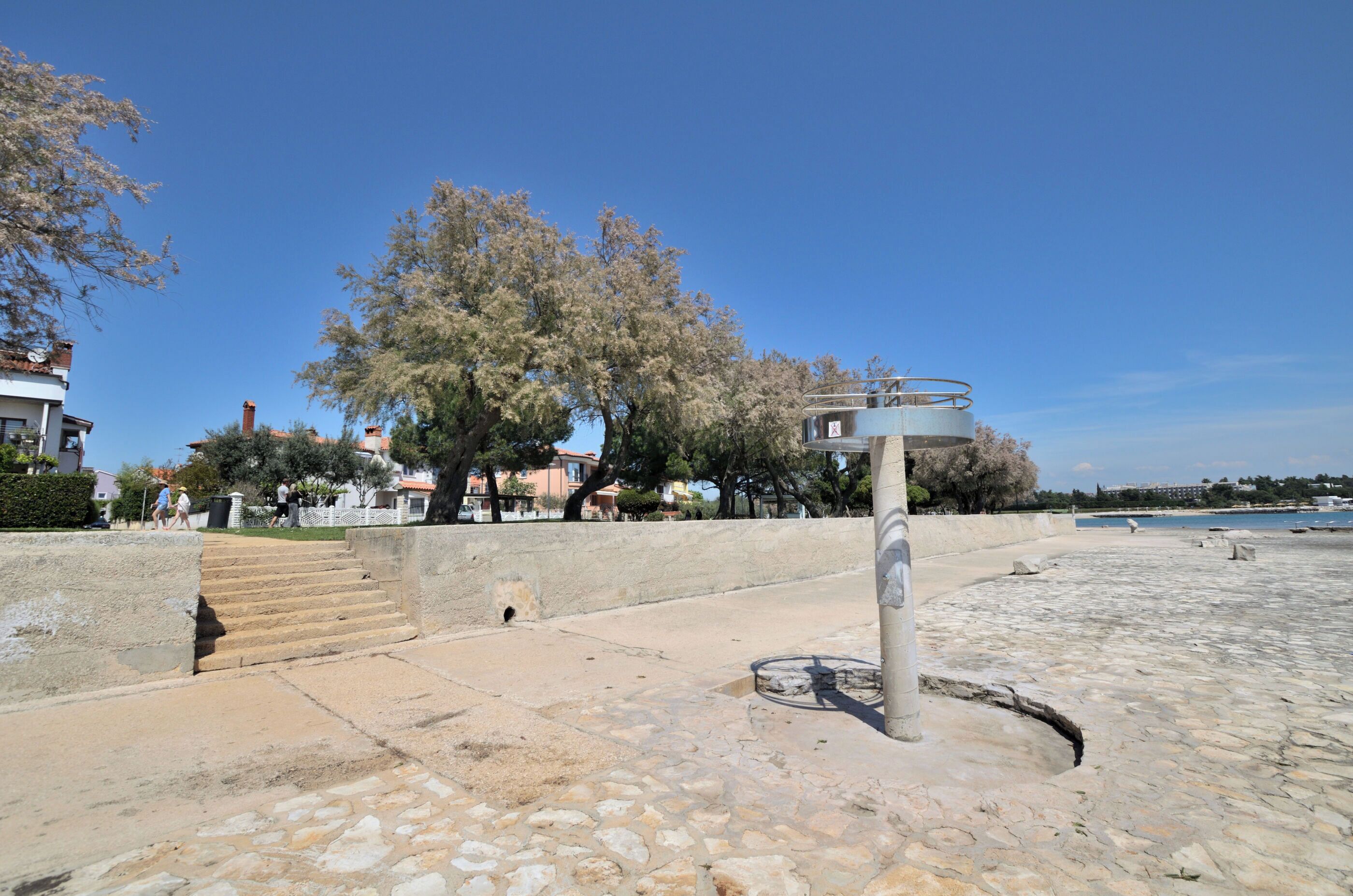 Un sendero de piedra que conduce a una playa con cielo despejado.