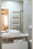A bathroom with a white sink, towel rack, and toilet.