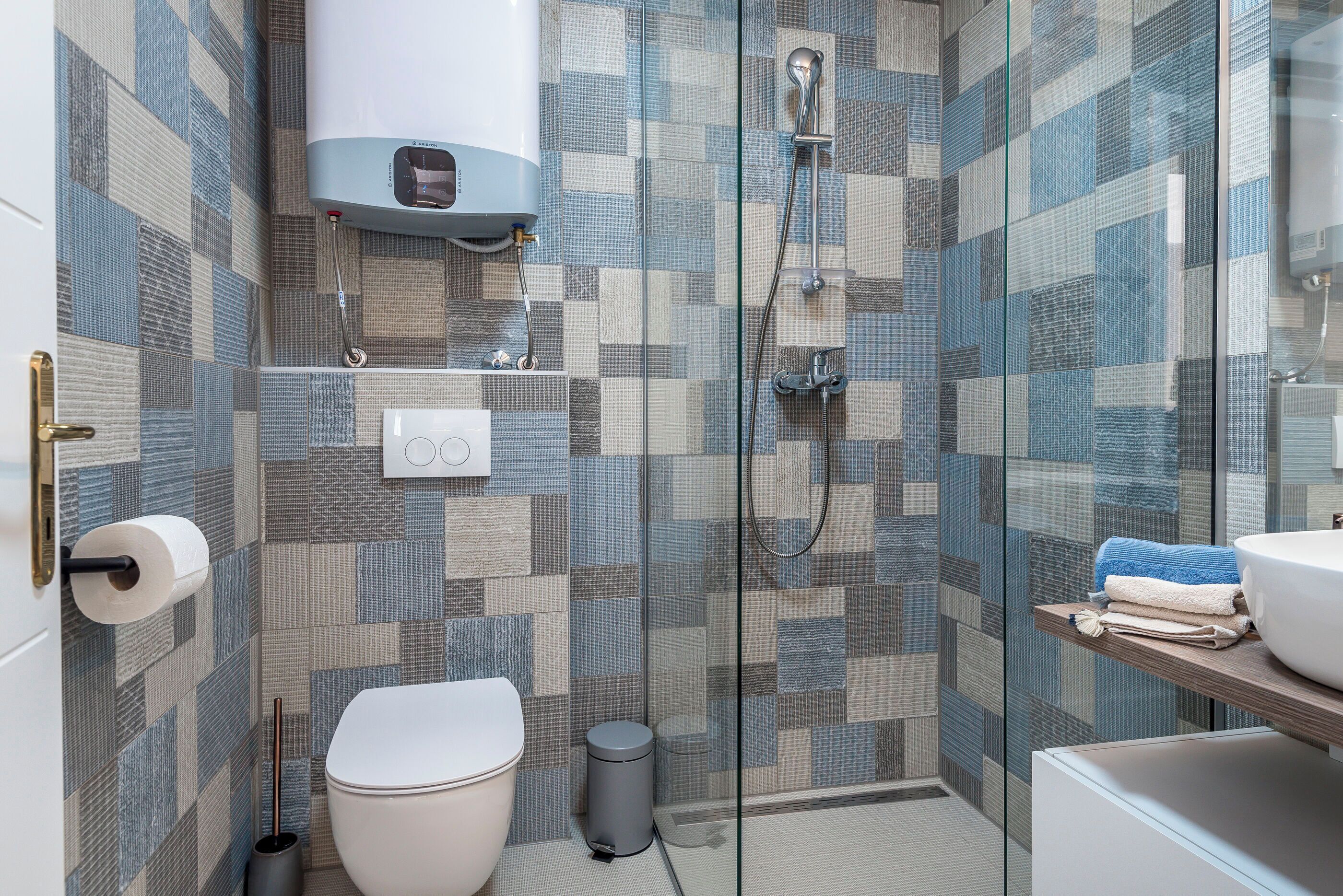 Et moderne badeværelse med toilet, bidet og bruseniche.