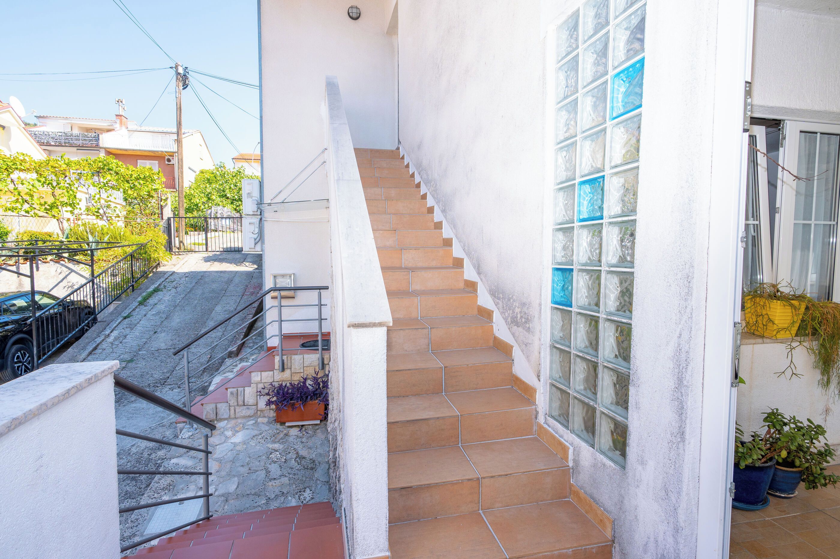 Un escalier menant à un balcon du deuxième étage, d’où l’on a vue sur la rue.