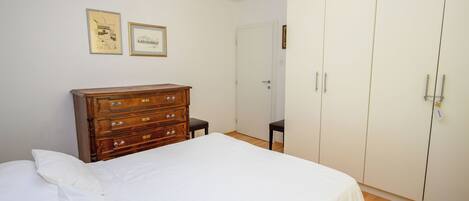 Une chambre à coucher avec un lit, une commode et une armoire.
