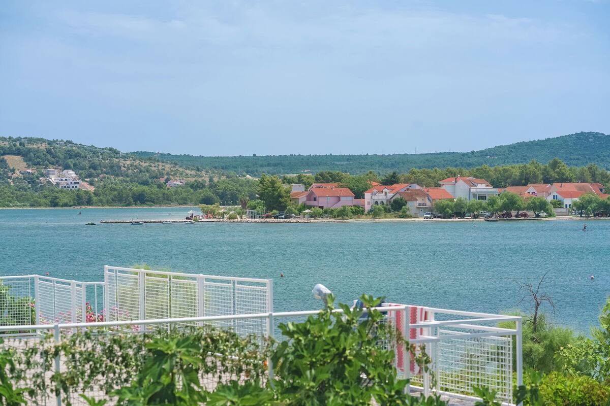A lakeside view with houses and a dock.