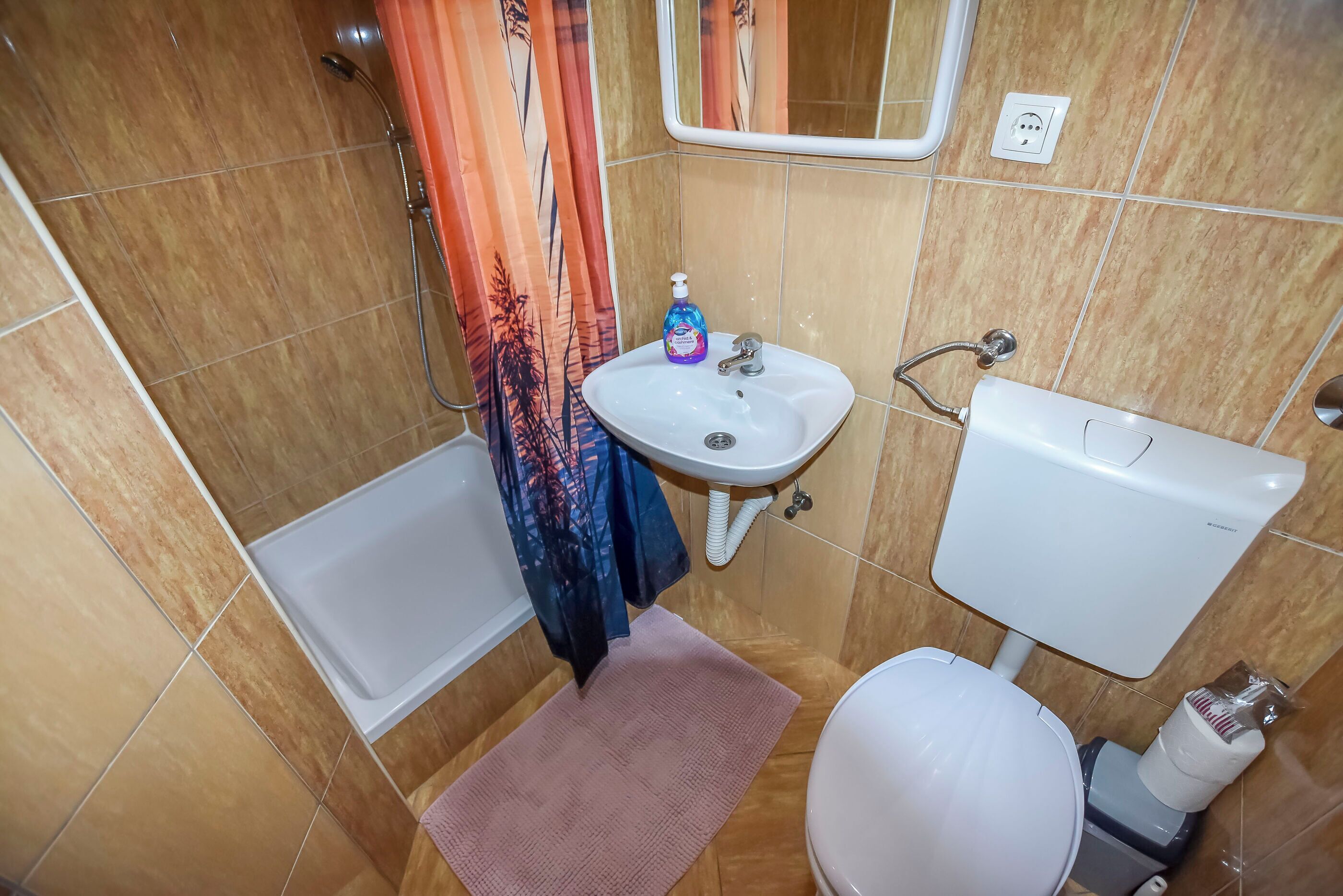 A bathroom with a bathtub, sink, toilet, and shower.