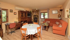 Un salon doté d’une cheminée en pierre, de meubles en bois et d’une grande fenêtre.