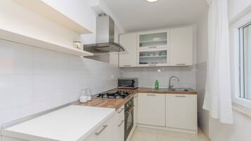 Appartement (A1) | Privékeuken | Een koelkast, een magnetron, een oven, een kookplaat