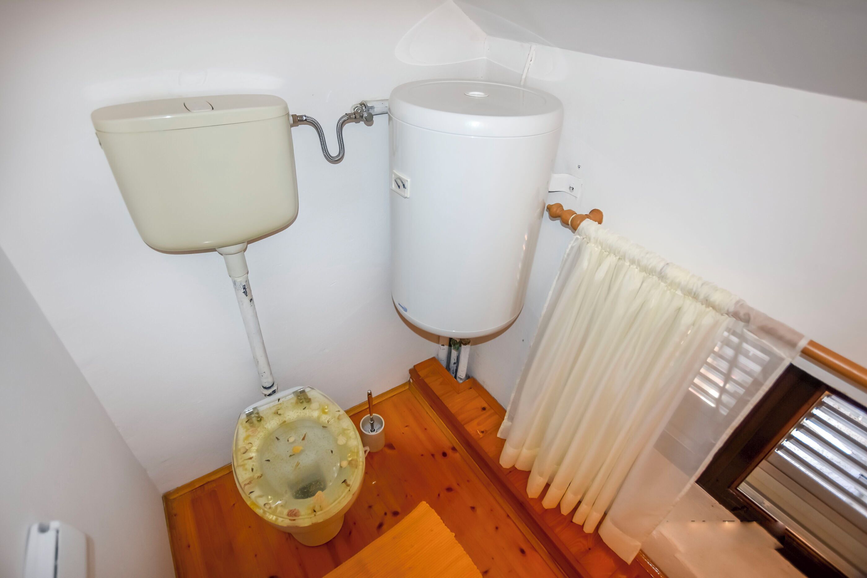 A bathroom with a toilet, sink, and a water heater.
