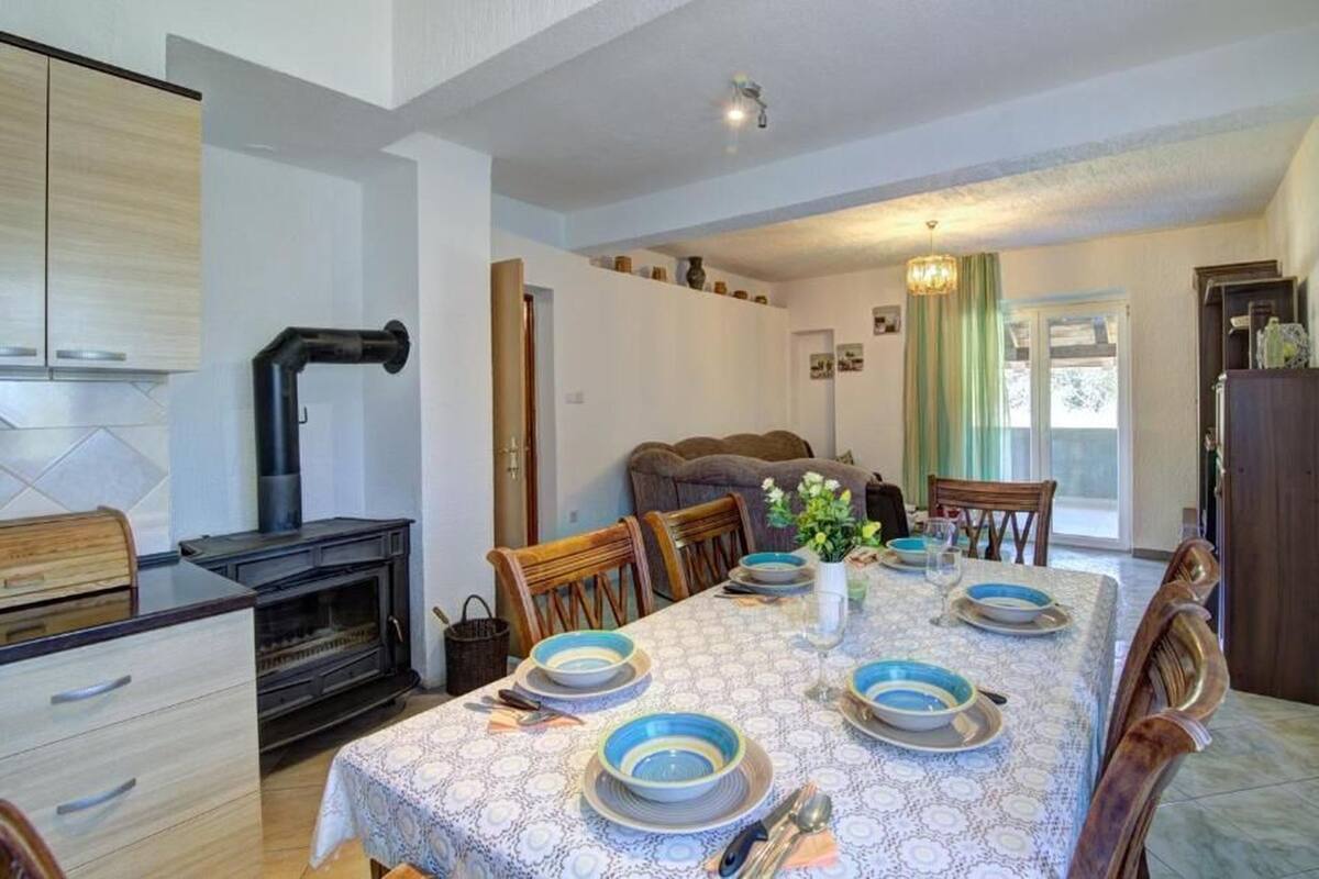 A dining area with a table set for four, a fireplace, and a view of the outdoors.