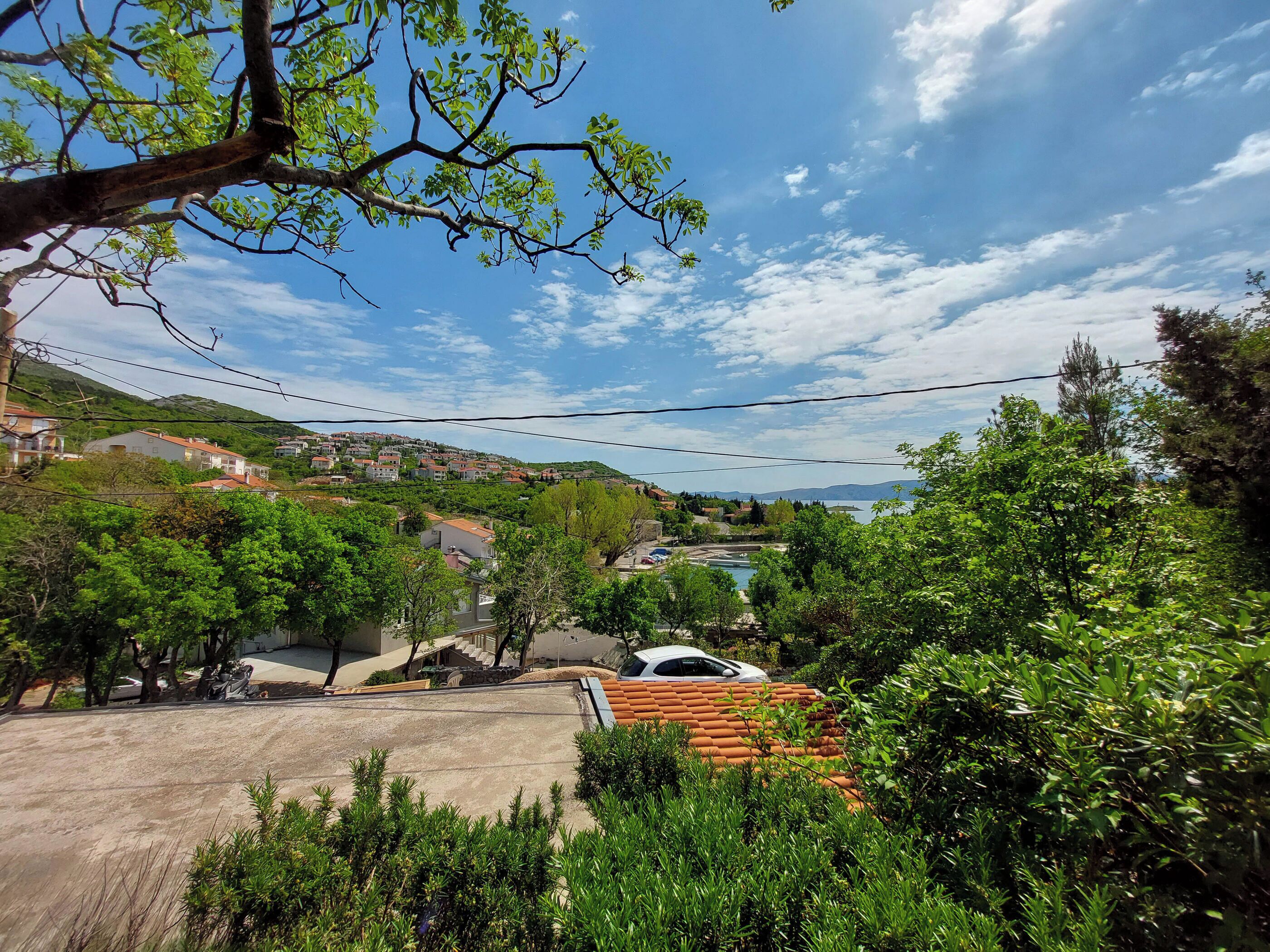 A residential area with houses, trees, and a clear sky.