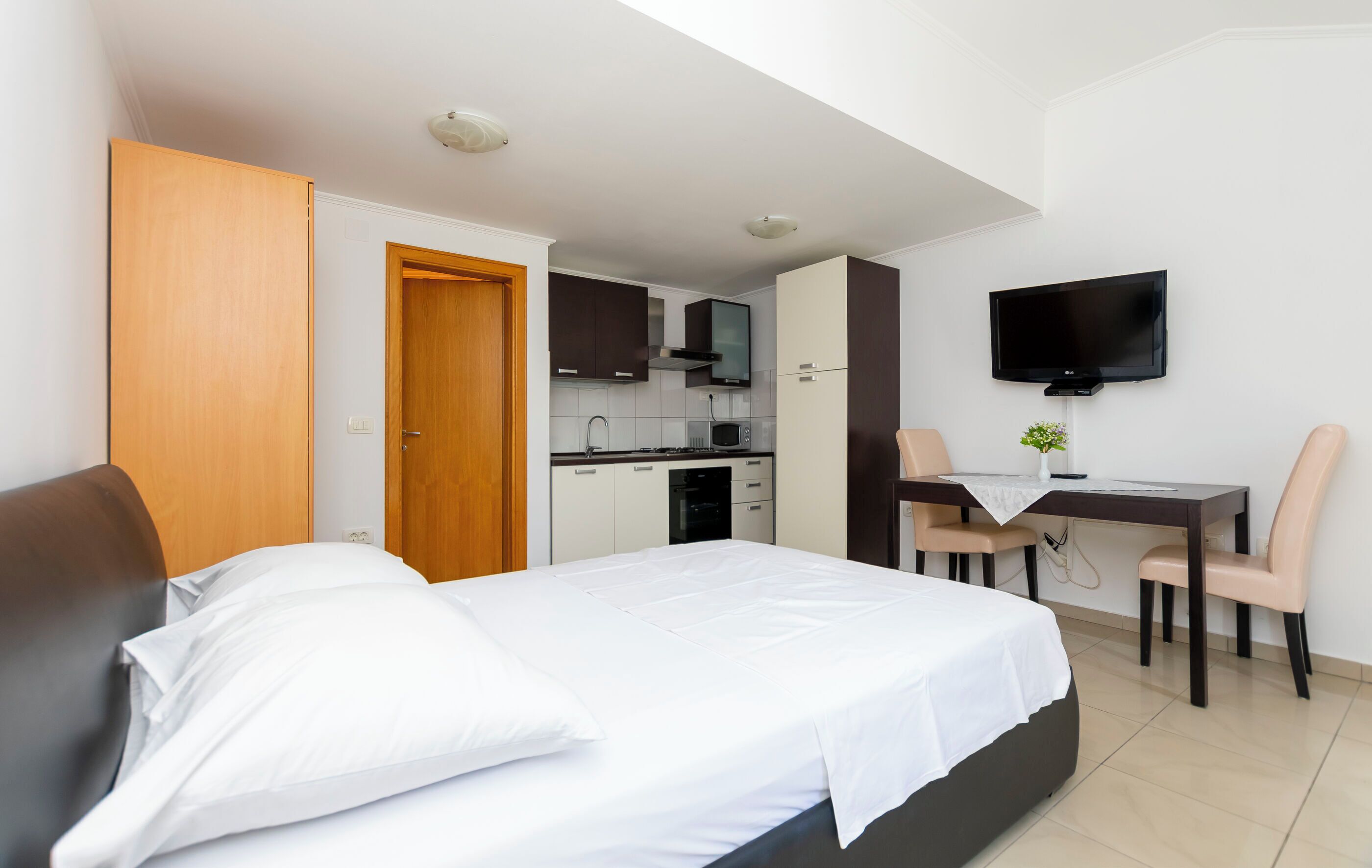Ein Schlafzimmer mit einem Bett, einem Schreibtisch und einem Fernseher.
