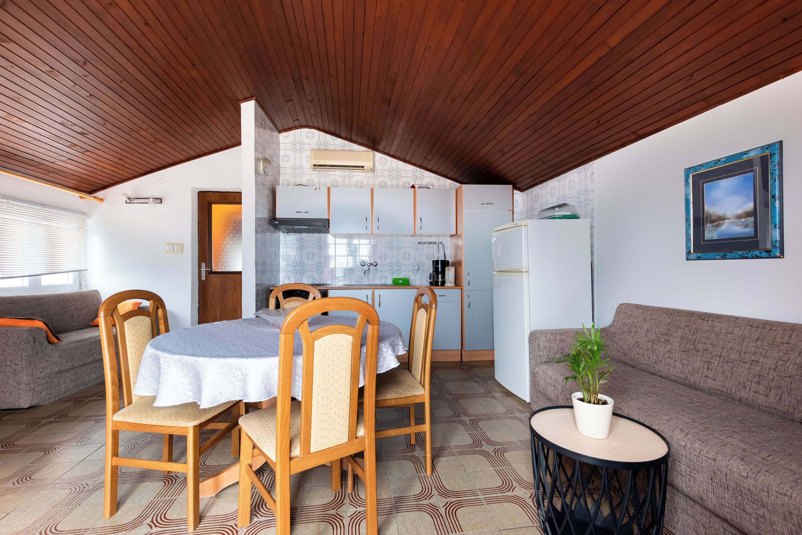 A compact living space with a dining area, kitchenette, and seating area.