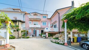 Un quartier résidentiel avec une maison à deux étages, une allée pavée et une voiture garée.