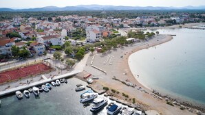A coastal town with a marina, beach, and residential buildings. - Apartment Sunshine (Vodice)