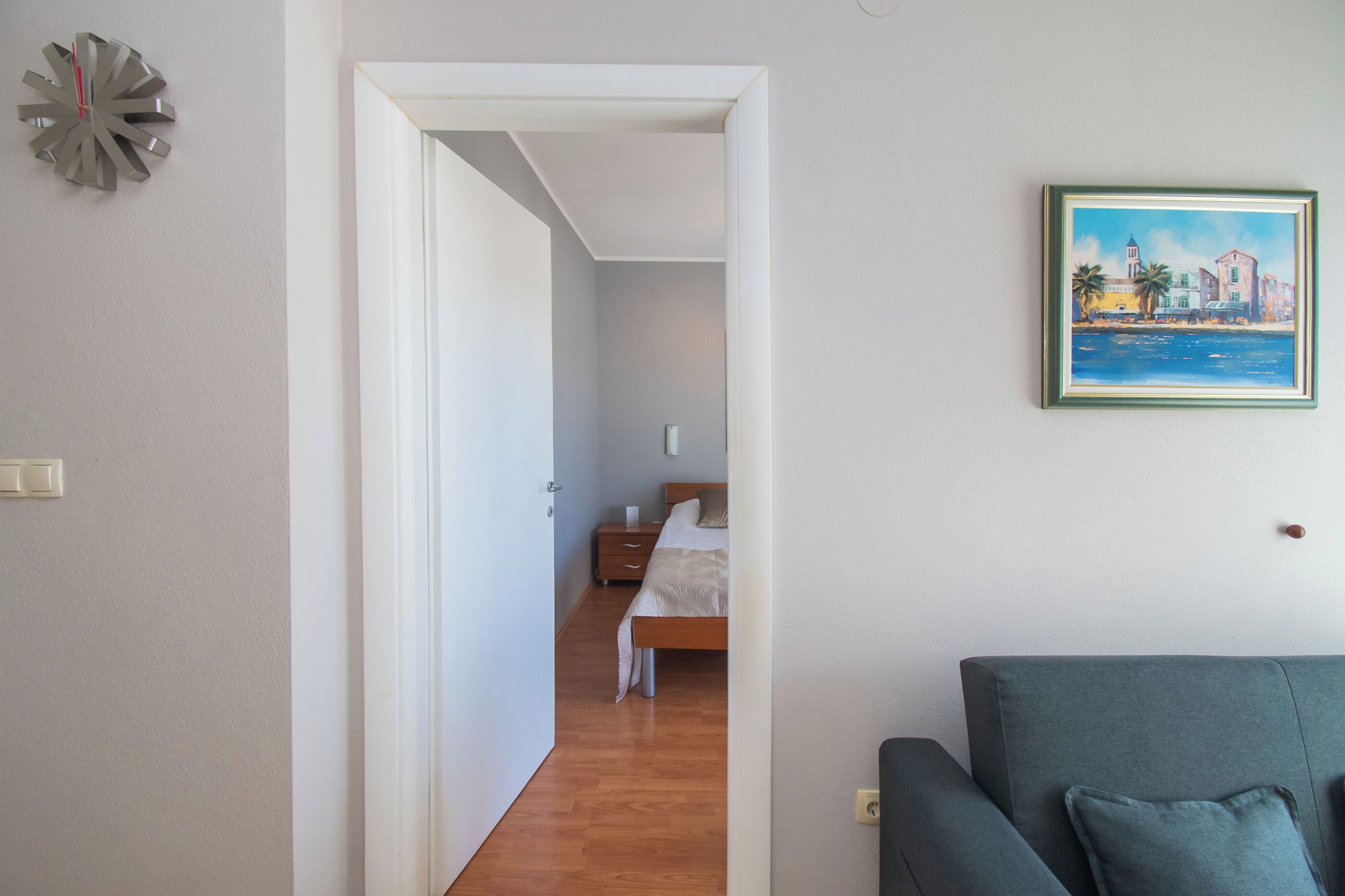 Une chambre à coucher avec un lit, une table de chevet et un tableau accroché au mur.