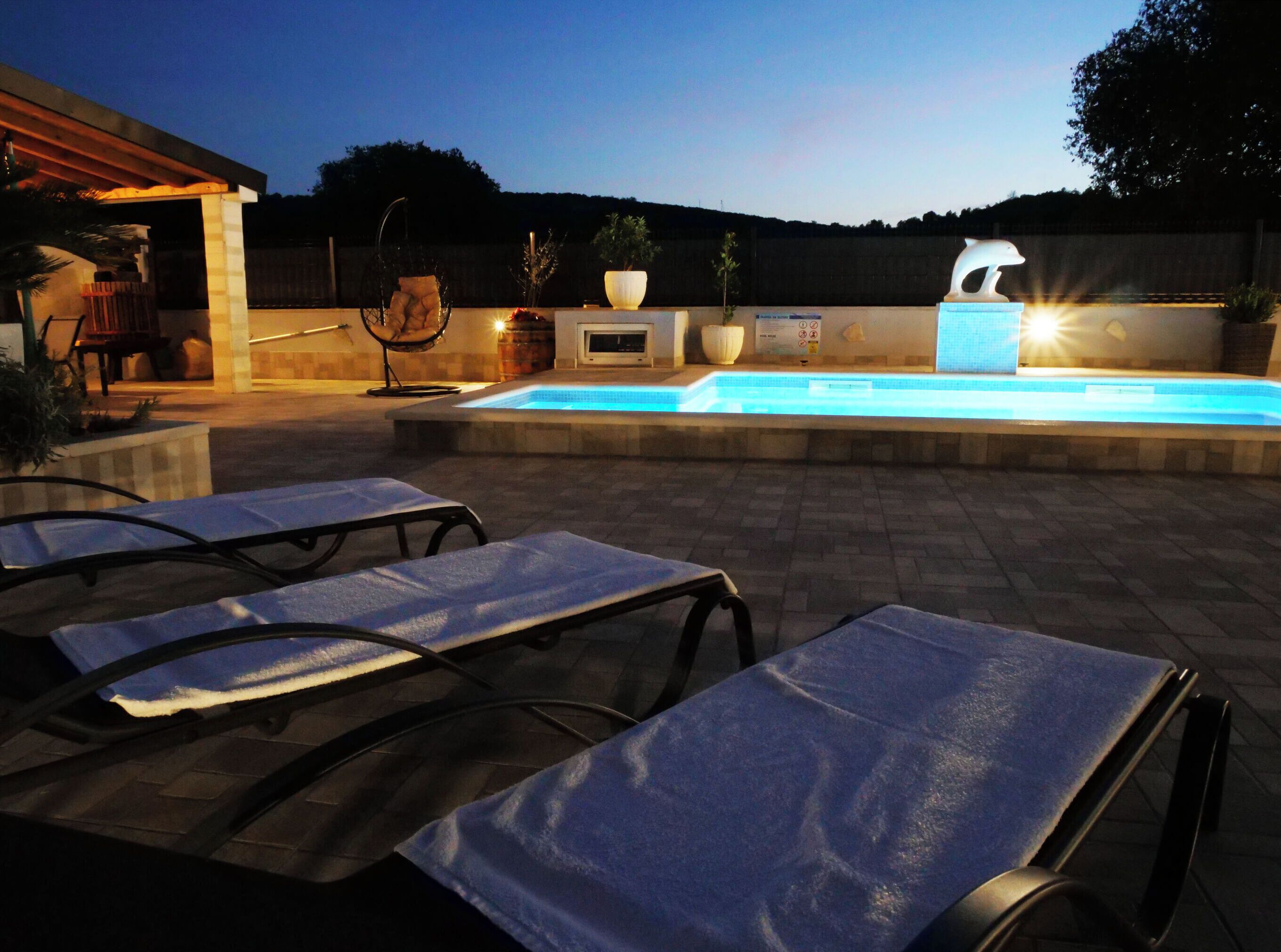 Una piscina al aire libre con sillones de descanso y un jacuzzi.