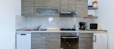 Appartement (A1) | Cuisine privée | Réfrigérateur, four à micro-ondes, un four, surface de cuisson