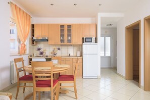 Una cucina moderna con mobili in legno, un frigorifero bianco e un tavolo da pranzo con sedie.