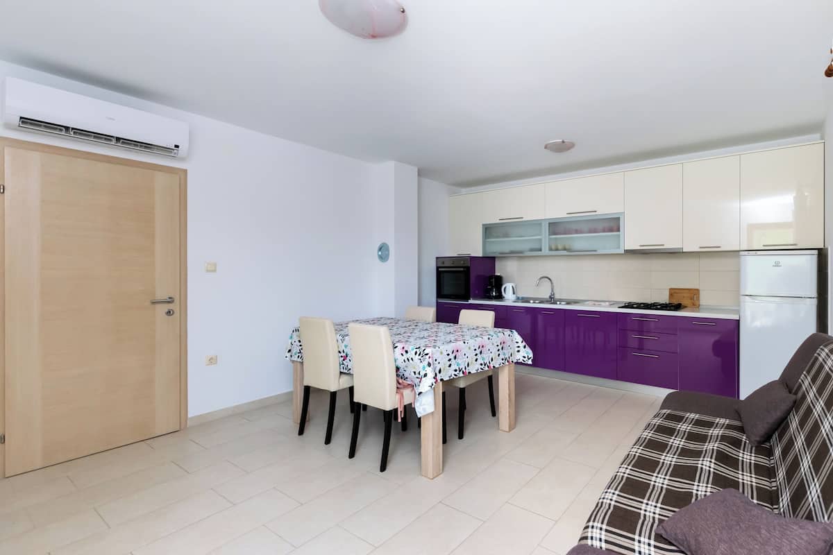 A compact living space with a dining area, kitchenette, and a sofa.