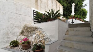 A staircase with potted plants and a white wall. - Apartments Plomin (Krsan)