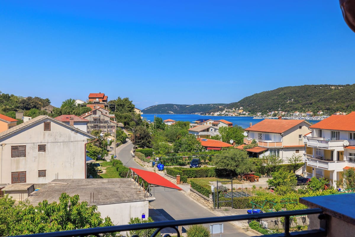 A coastal town with terraced houses, a clear blue sky, and a view of the sea.