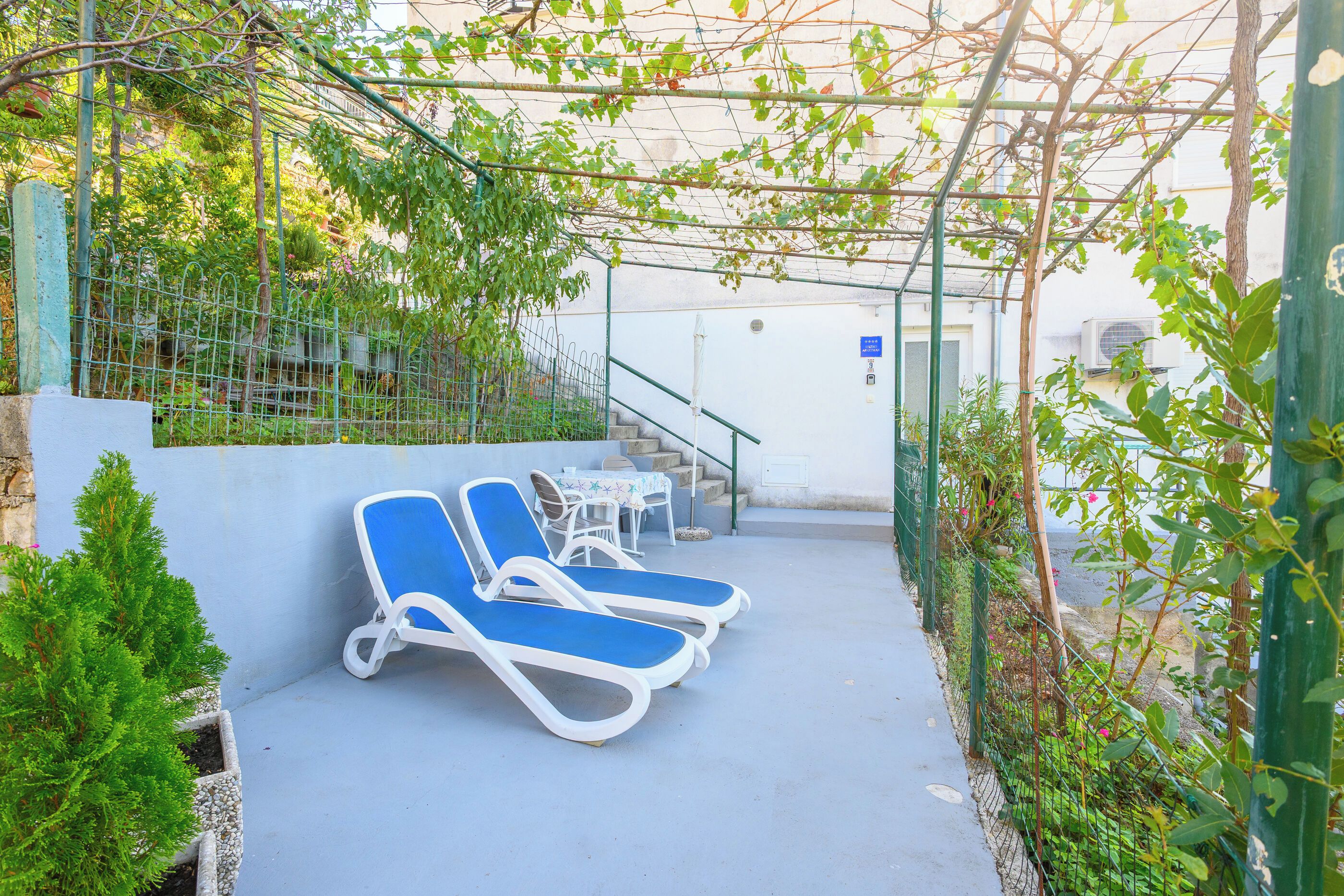 A covered outdoor seating area with lounge chairs and a table.