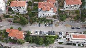 Luchtbeeld van een kustwoongebied met meerdere gebouwen, een parkeerplaats en boten in het water.