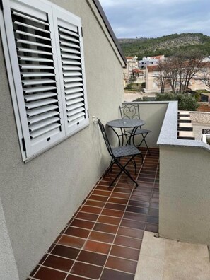 A balcony with a tiled floor, a table, and two chairs. - Apartments Ideal Holiday (Tribunj)