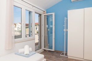 A room with a bed, a window with curtains, a sliding glass door, and a wardrobe. - Apartments Ideal Holiday (Tribunj)