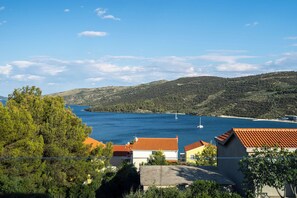 A coastal village with houses having red-tiled roofs, a clear blue sea, and a hilly backdrop. - Apartment Ana (Marina)