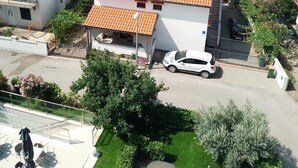 Et boligområde med huse med røde tagsten, en hvid bygning med balkoner og havudsigt i baggrunden.