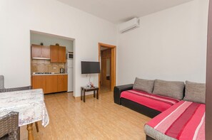 A compact living space with a kitchenette, a dining area, and a sofa. - Apartments Rusan (Vodice)