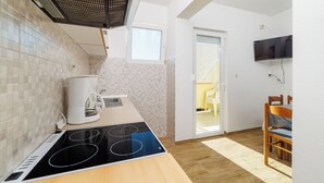 Une cuisine moderne équipée d’une cuisinière intégrée, d’une machine à café et d’une fenêtre.