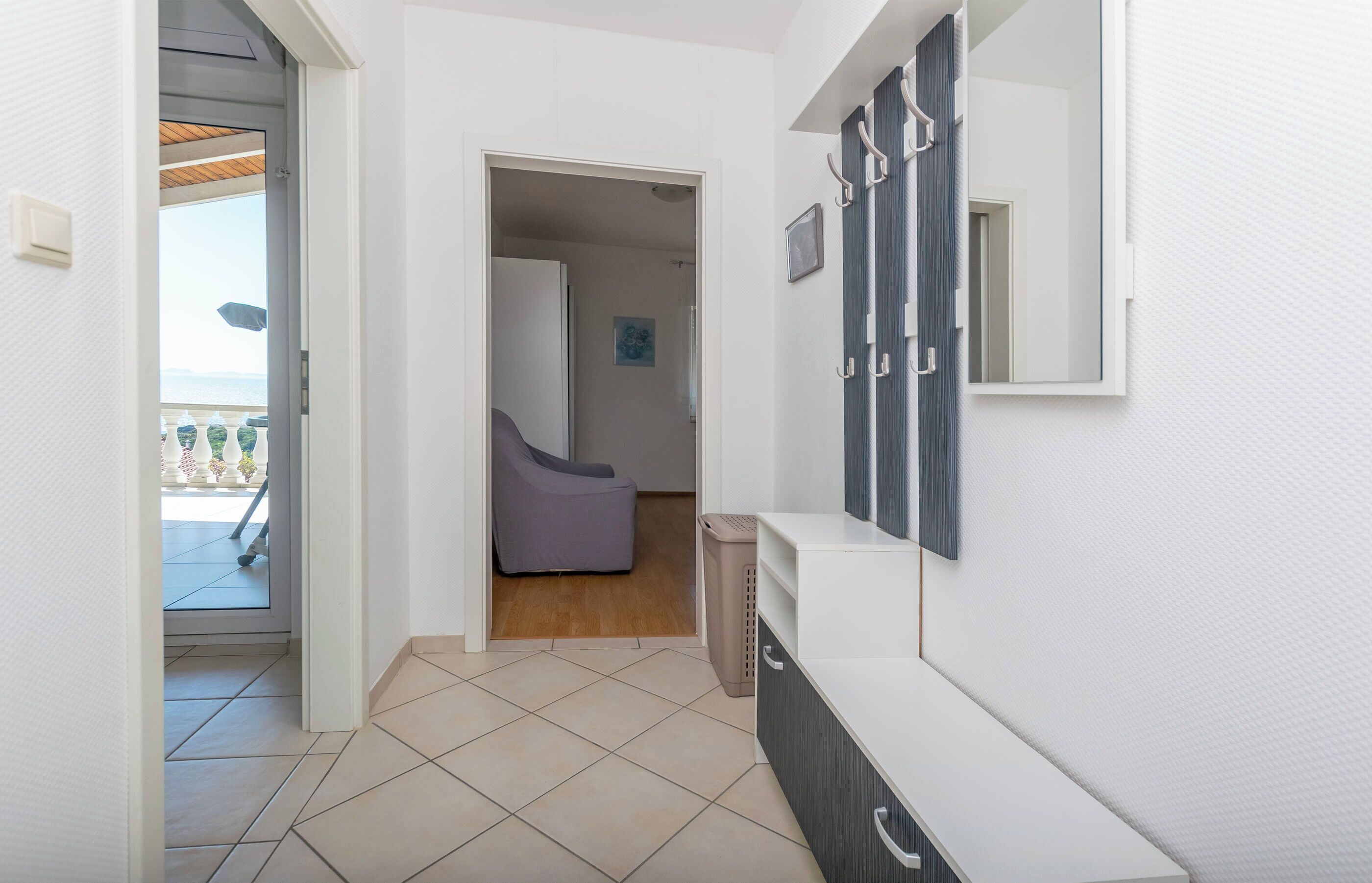 Uma casa de banho moderna com um espelho grande, um porta-toalhas e um cesto de lixo.