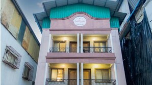 A building with a sign that reads "The Sangam." It has multiple balconies with metal railings and windows with blinds. - The Sangam Hotel Mahabaleshwar (Mahabaleshwar)