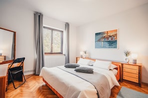 Un dormitorio moderno con una cama grande, un escritorio y una ventana con cortinas.
