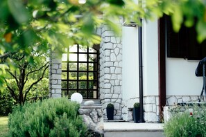A stone building with a large window and a door, surrounded by greenery. - Apartment Peaceful Paradise (Bakar)