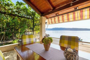 A table with a potted plant, a basket with a candle, and a view of the sea. - Apartment Haus Kicer (Kraljevica)