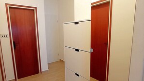 A hallway with a wooden floor, a white wall, and two doors. - Apartment Prcela 1 (Primosten)