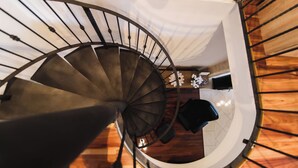 Una scala a chiocciola con pavimento in legno e parete bianca.