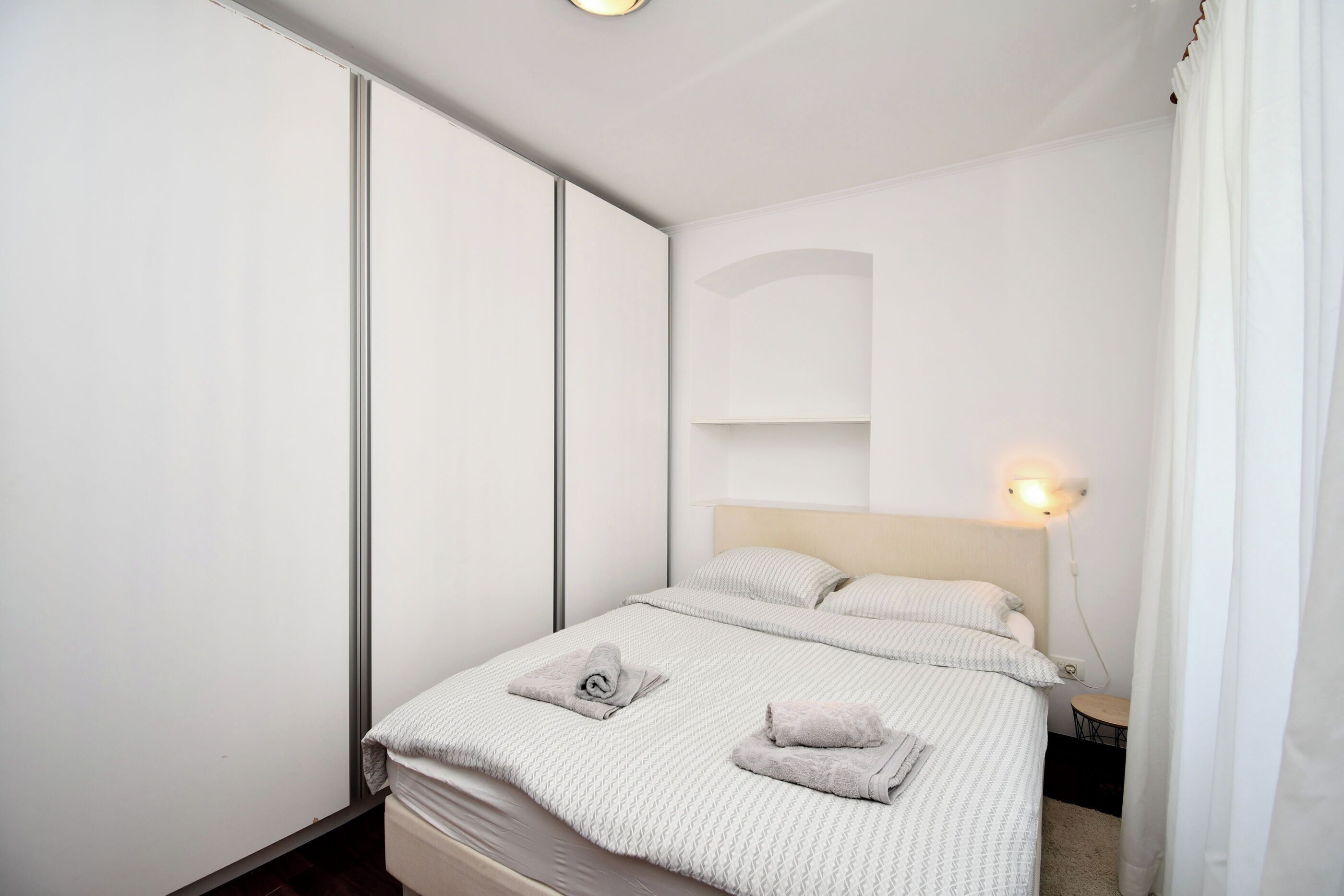 A modern bedroom with a bed, bedside tables, and a nightstand.