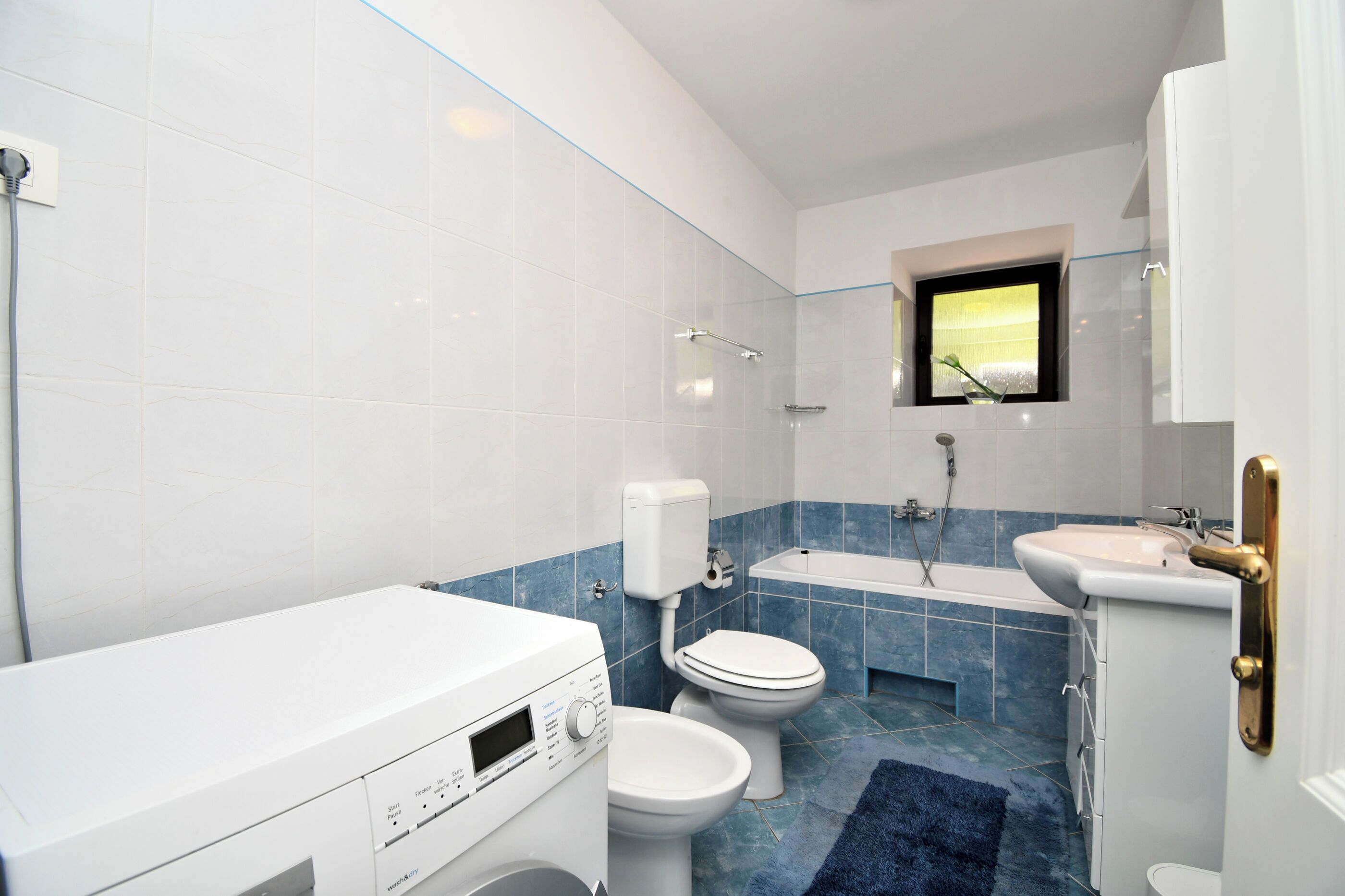 A modern bathroom with a toilet, sink, and bathtub.