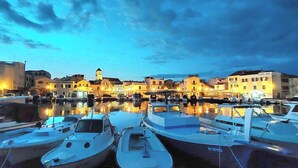 Un puerto deportivo con barcos amarrados, edificios al fondo y cielo despejado.