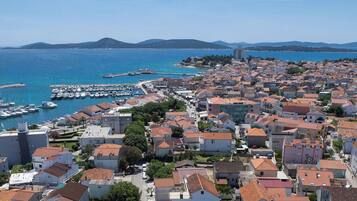 A coastal town with a marina, dense housing, and a prominent building in the background.